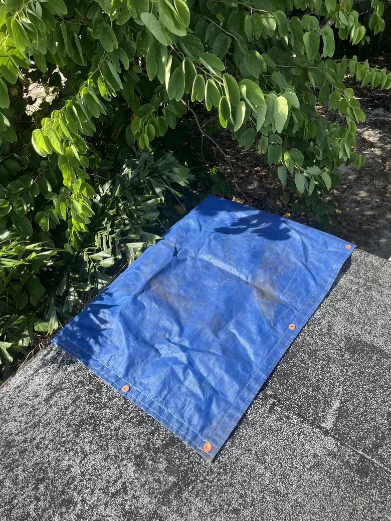 A tarp secured flat over the damaged area, keeping the weather out
